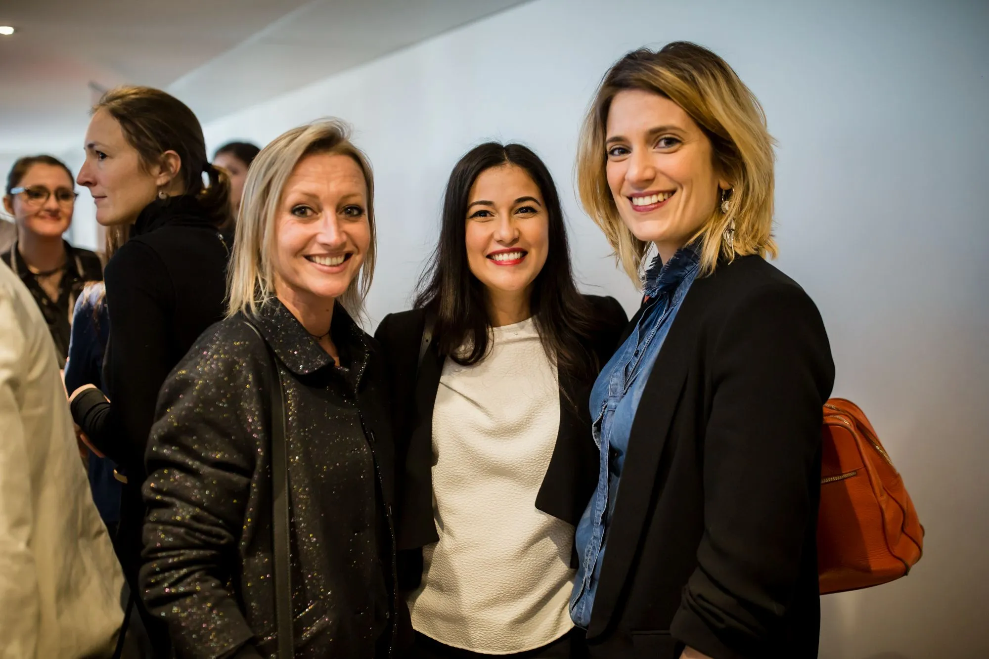 Trois collaboratrices souriantes pendant la réception