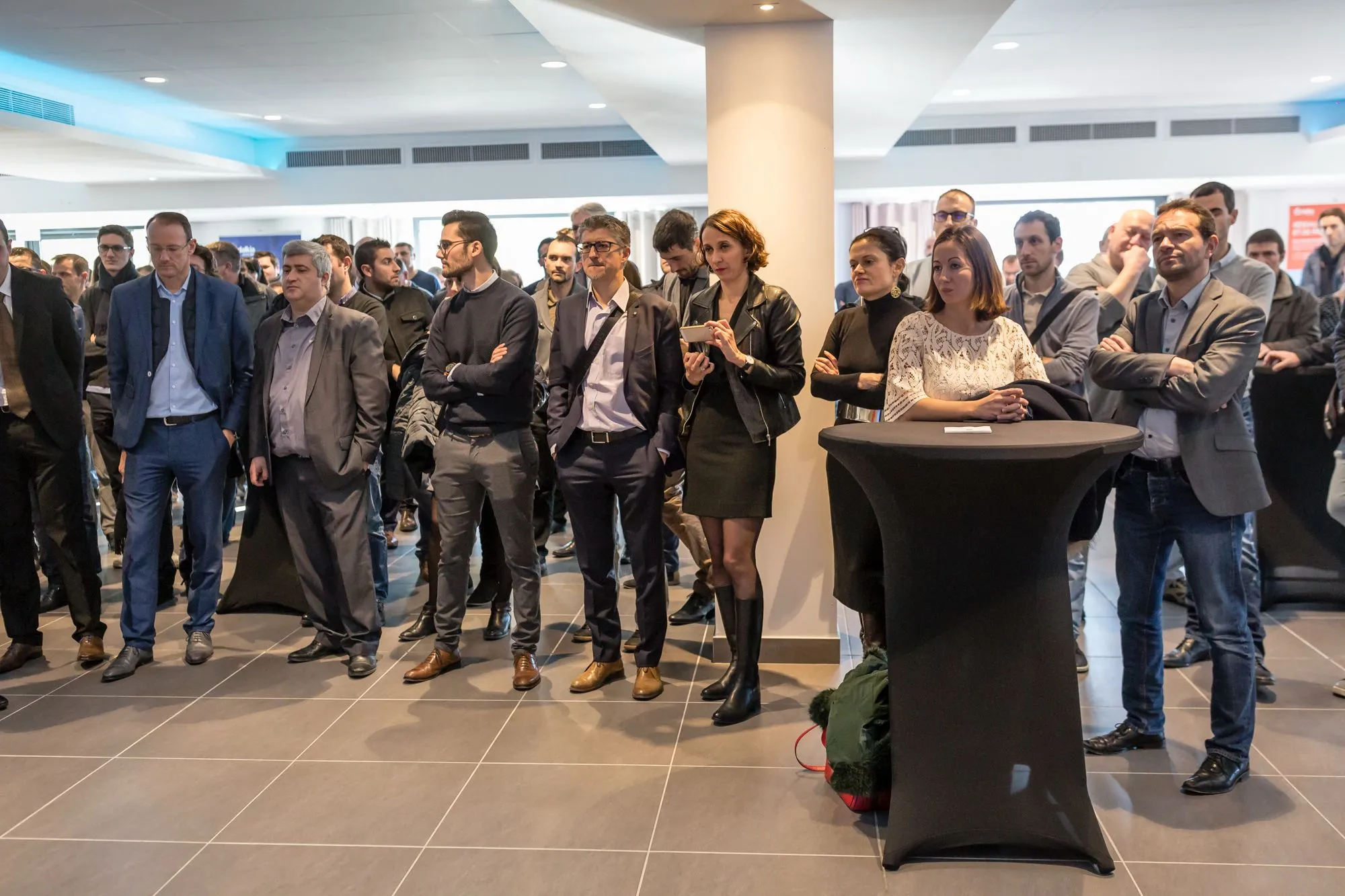 Invités autour des mange-debout pendant les discours