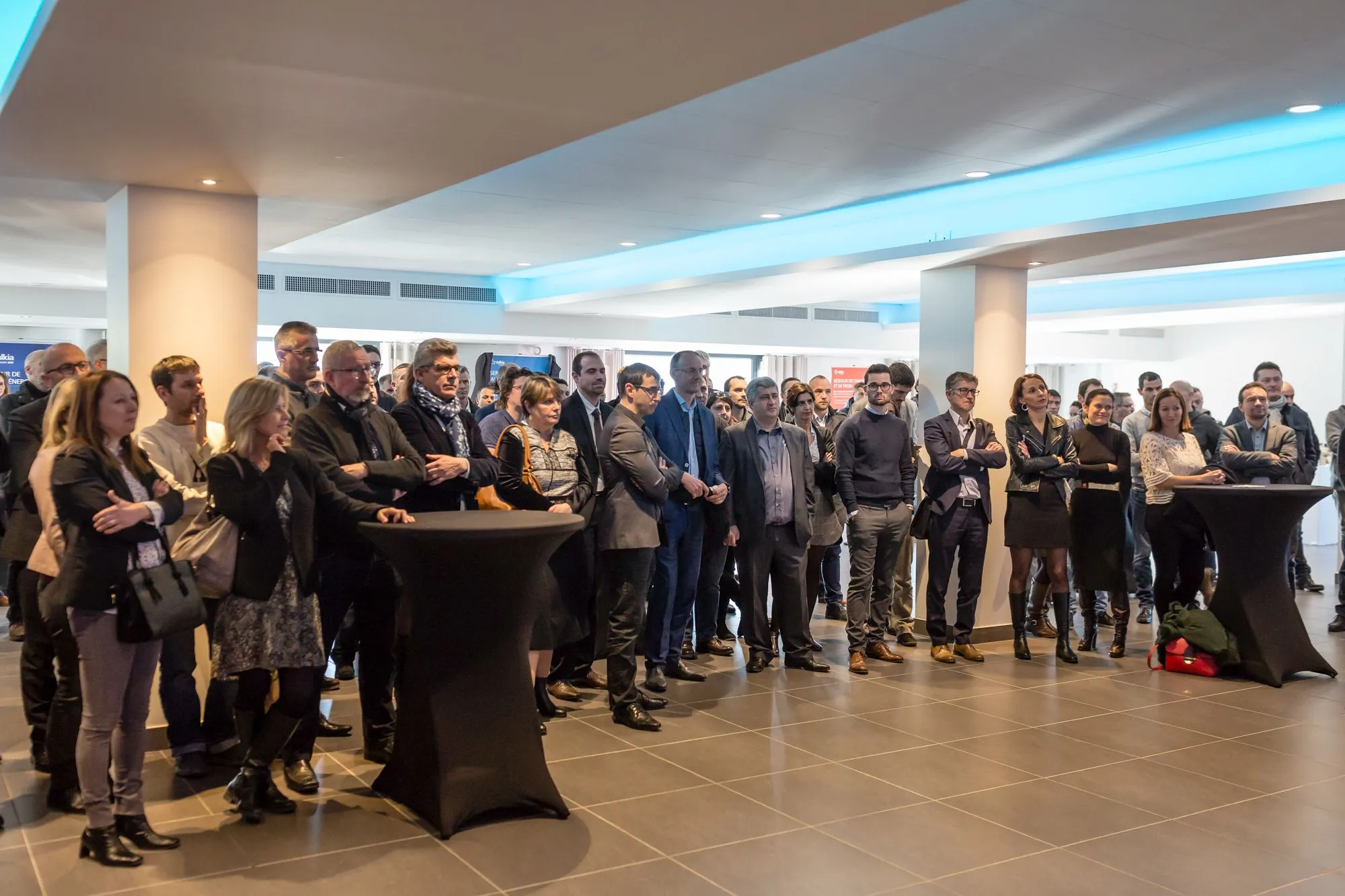 Collaborateurs rassemblés autour de tables hautes