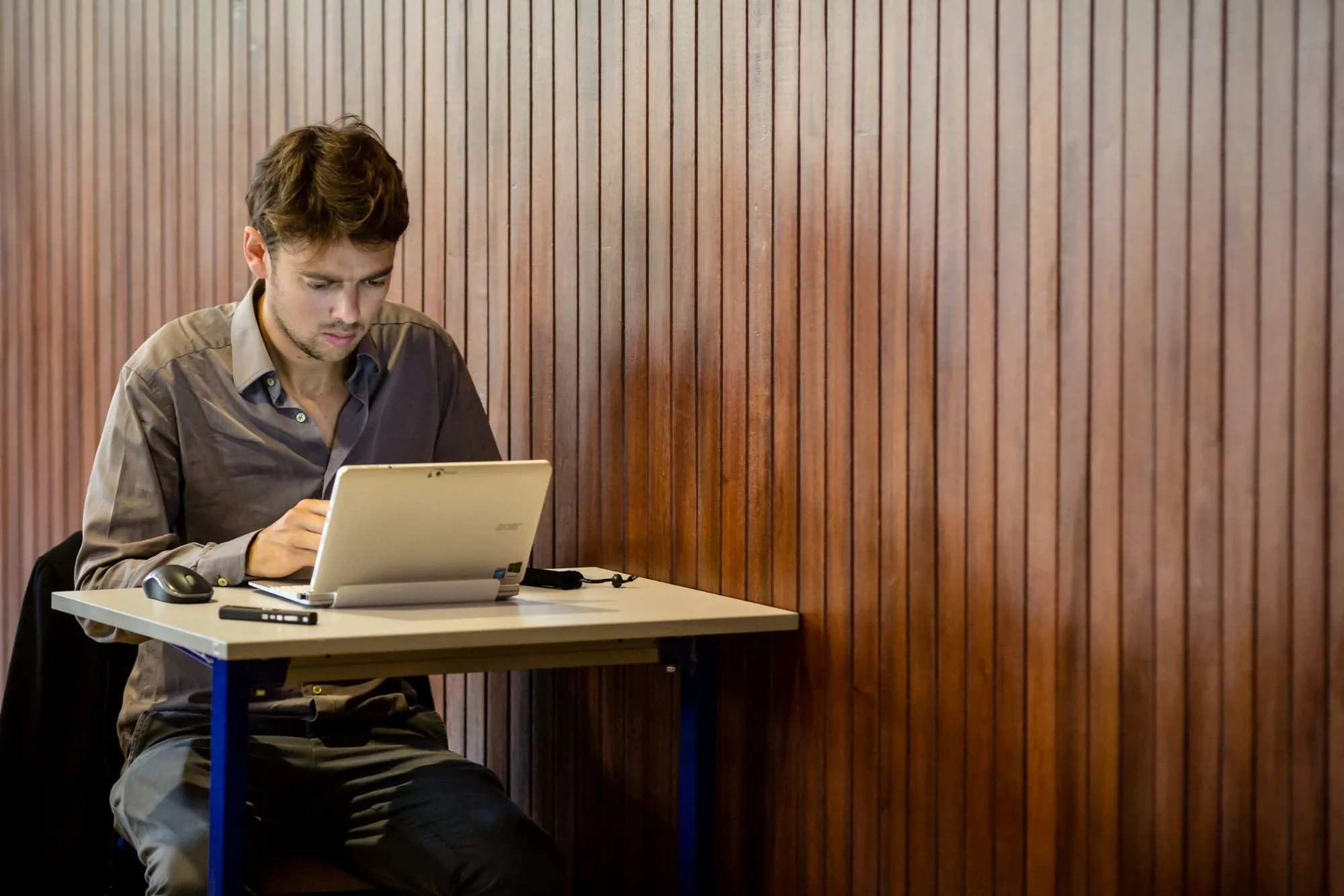 Jeune homme travaillant sur un ordinateur portable au pied de la tribune