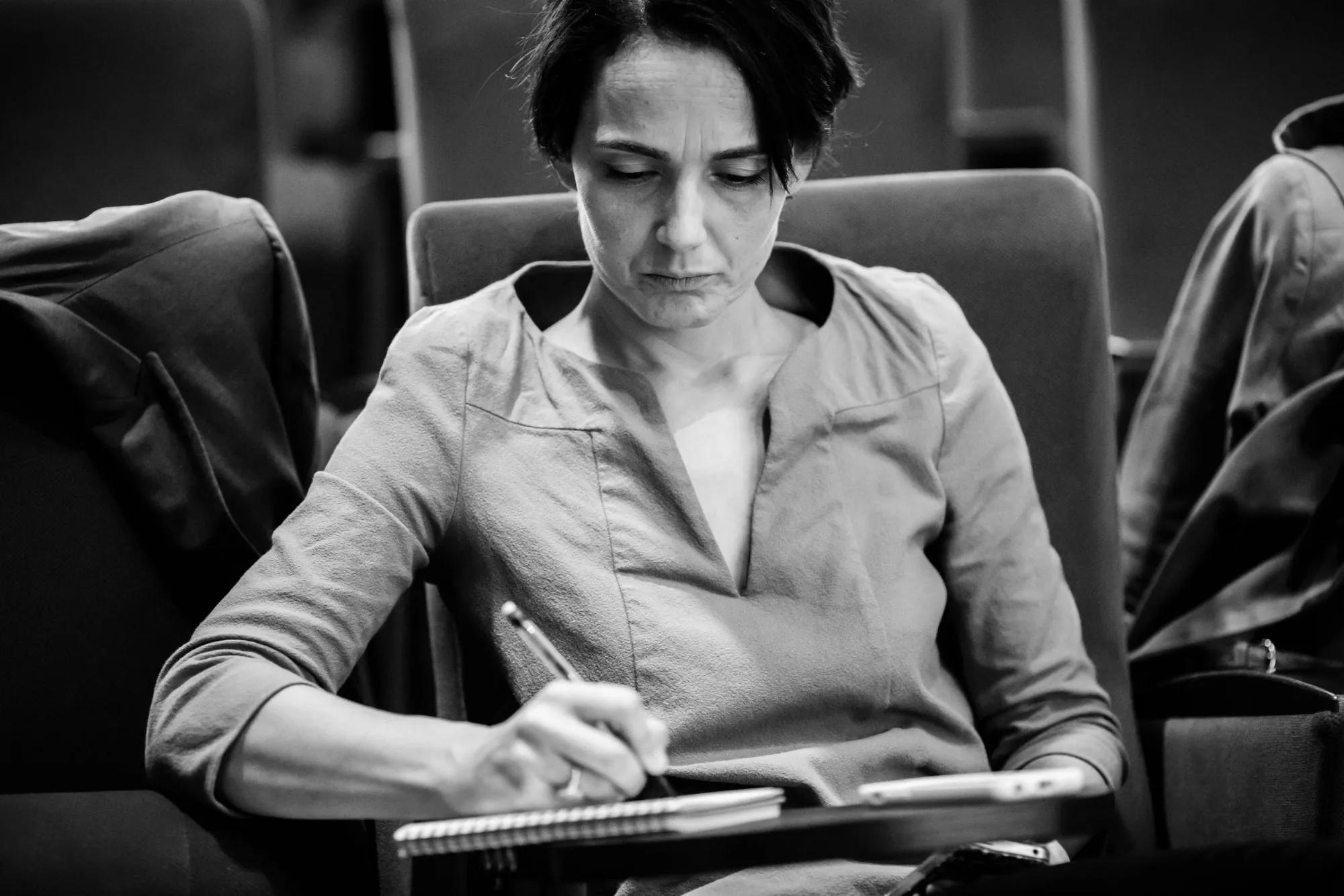 Portrait noir et blanc d'une participante prenant des notes