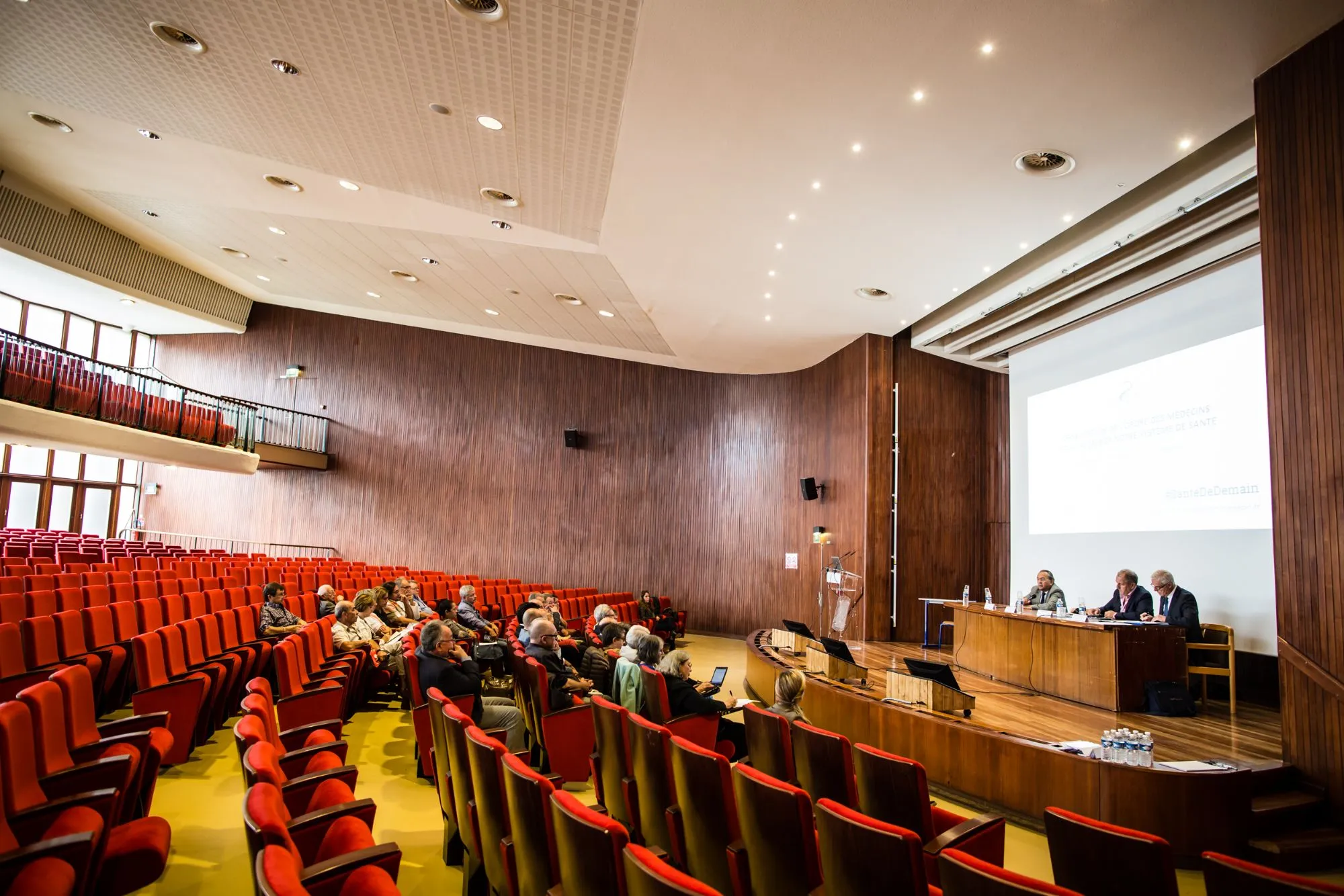 Vue d'ensemble de l'amphithéâtre boisé pendant une intervention