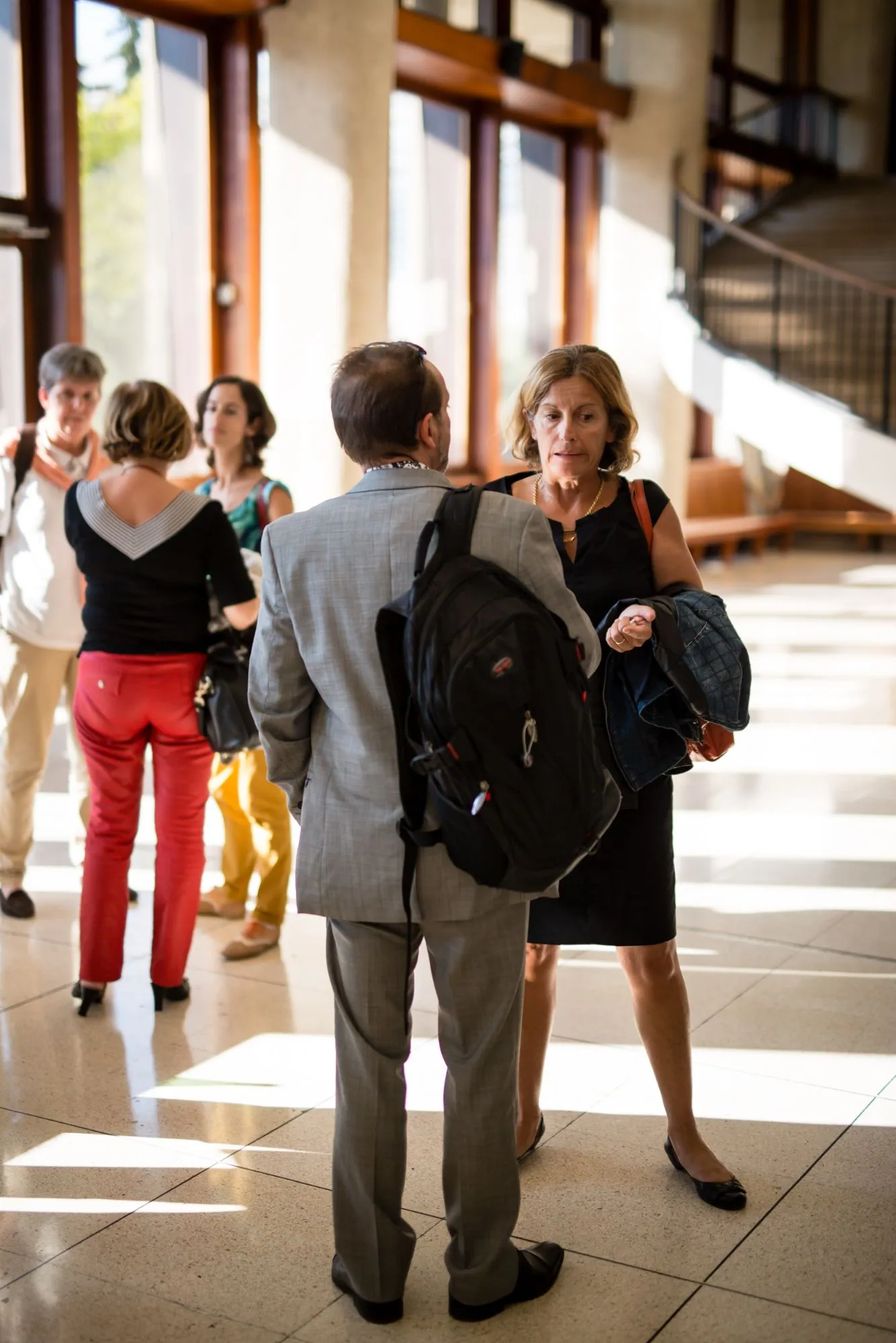 Participants discutant debout dans le hall lumineux