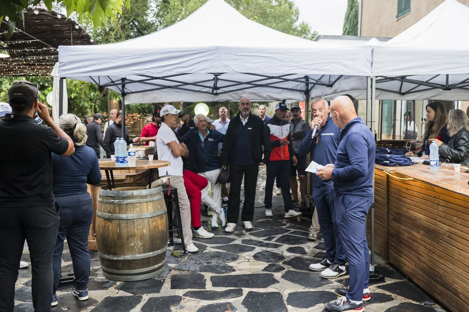 Accueil des joueurs sous les tentes, tables hautes et tonneau