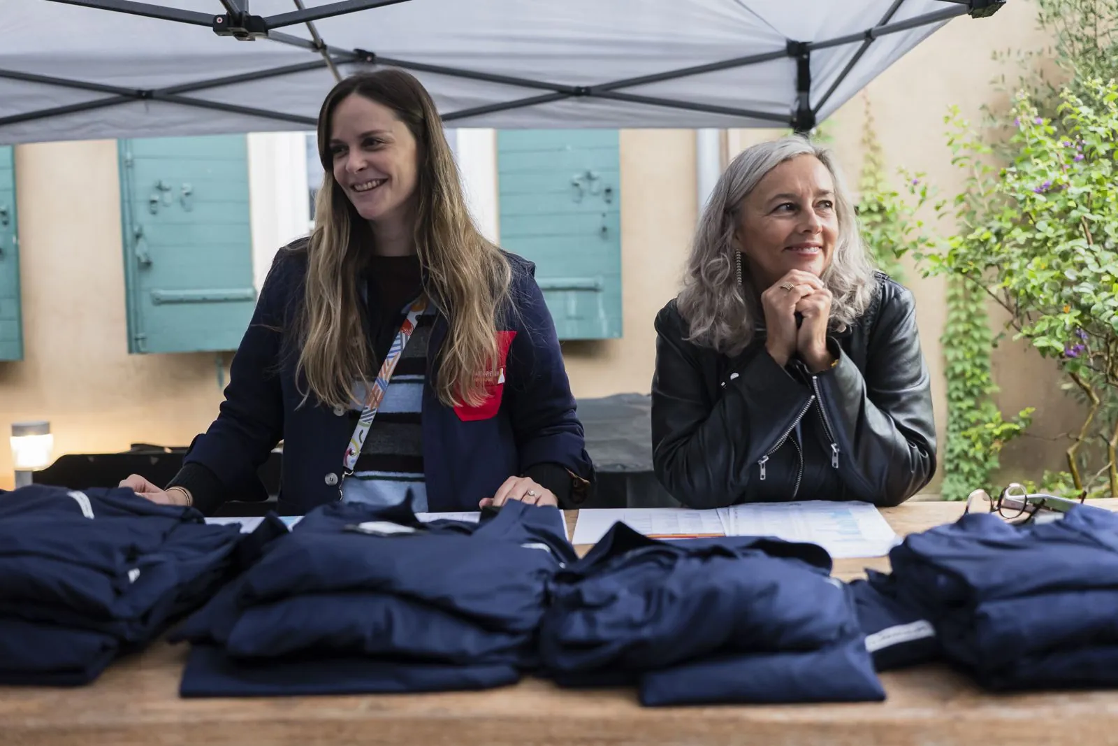 Deux hôtesses assises à la table de distribution des polos