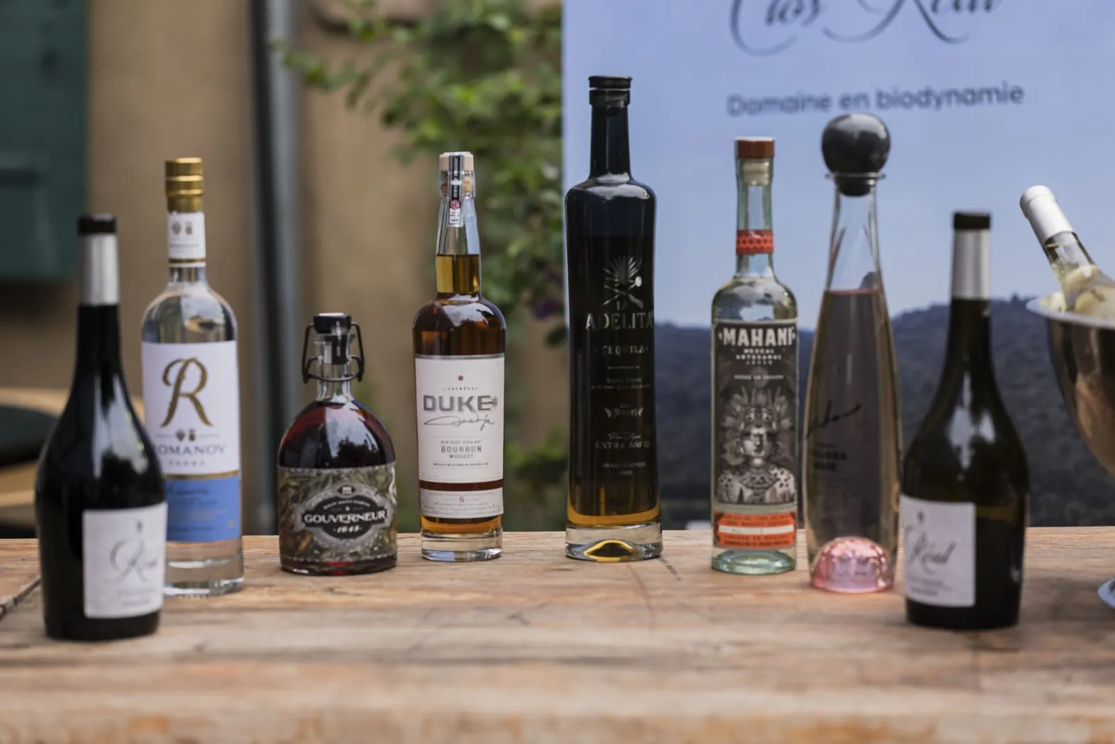Bouteilles de vins et spiritueux alignées sur une table en bois