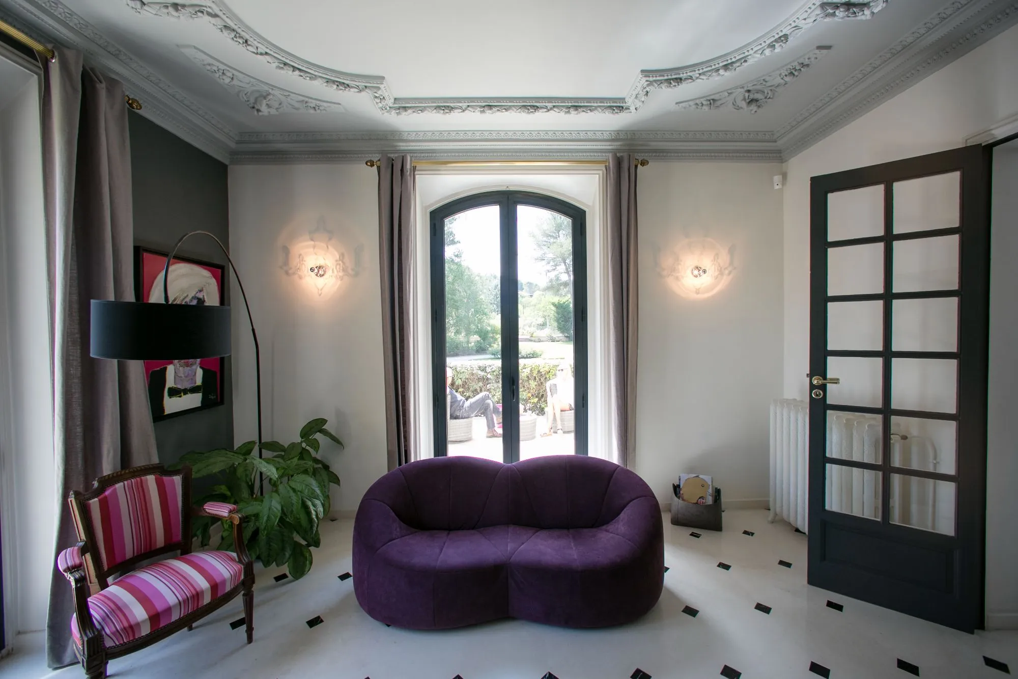 Salon aux fauteuils violets devant une porte-fenêtre