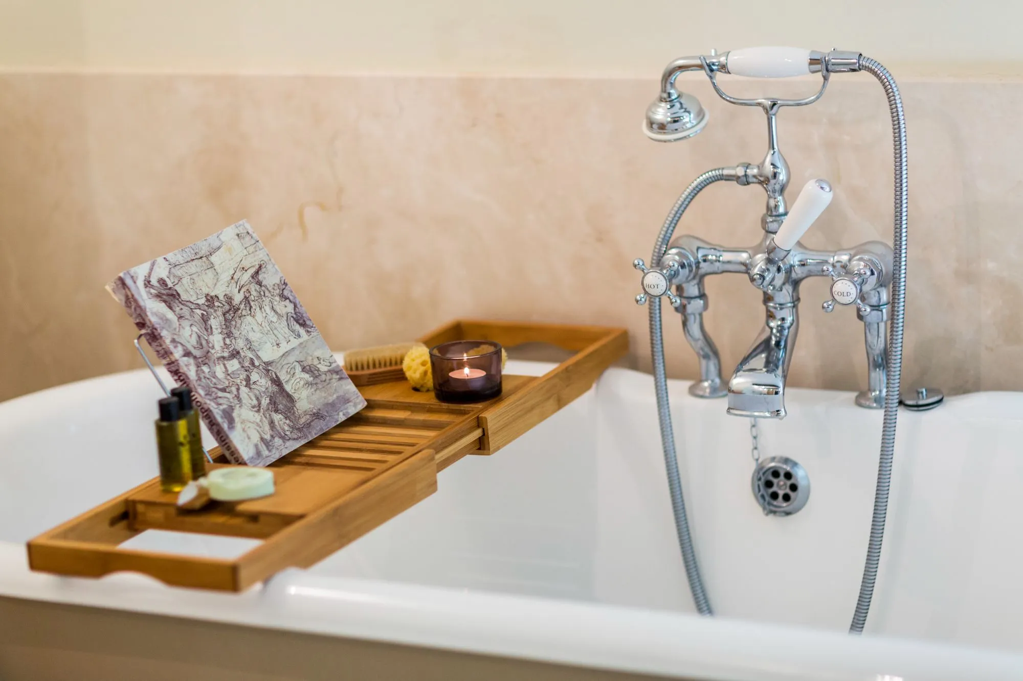 Détail d'une baignoire avec robinetterie ancienne et plateau en bois