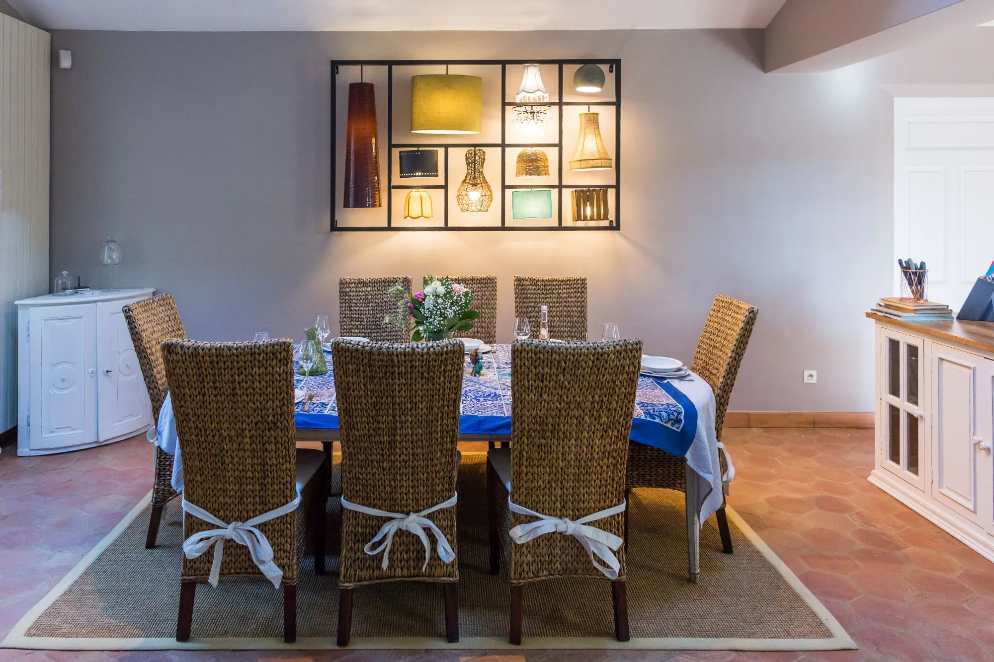 Salle à manger avec table dressée et chaises en osier