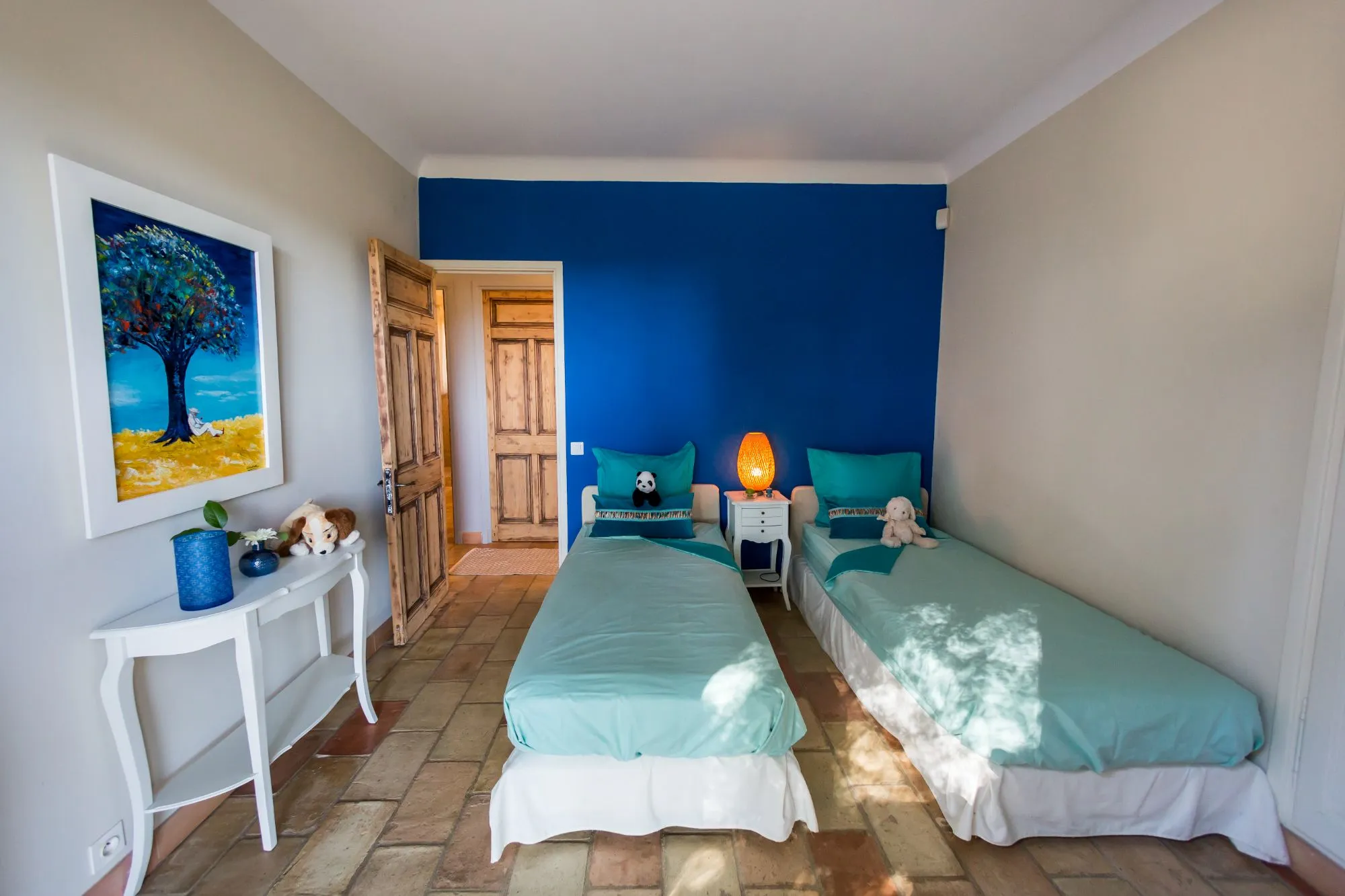 Chambre à deux lits avec mur bleu