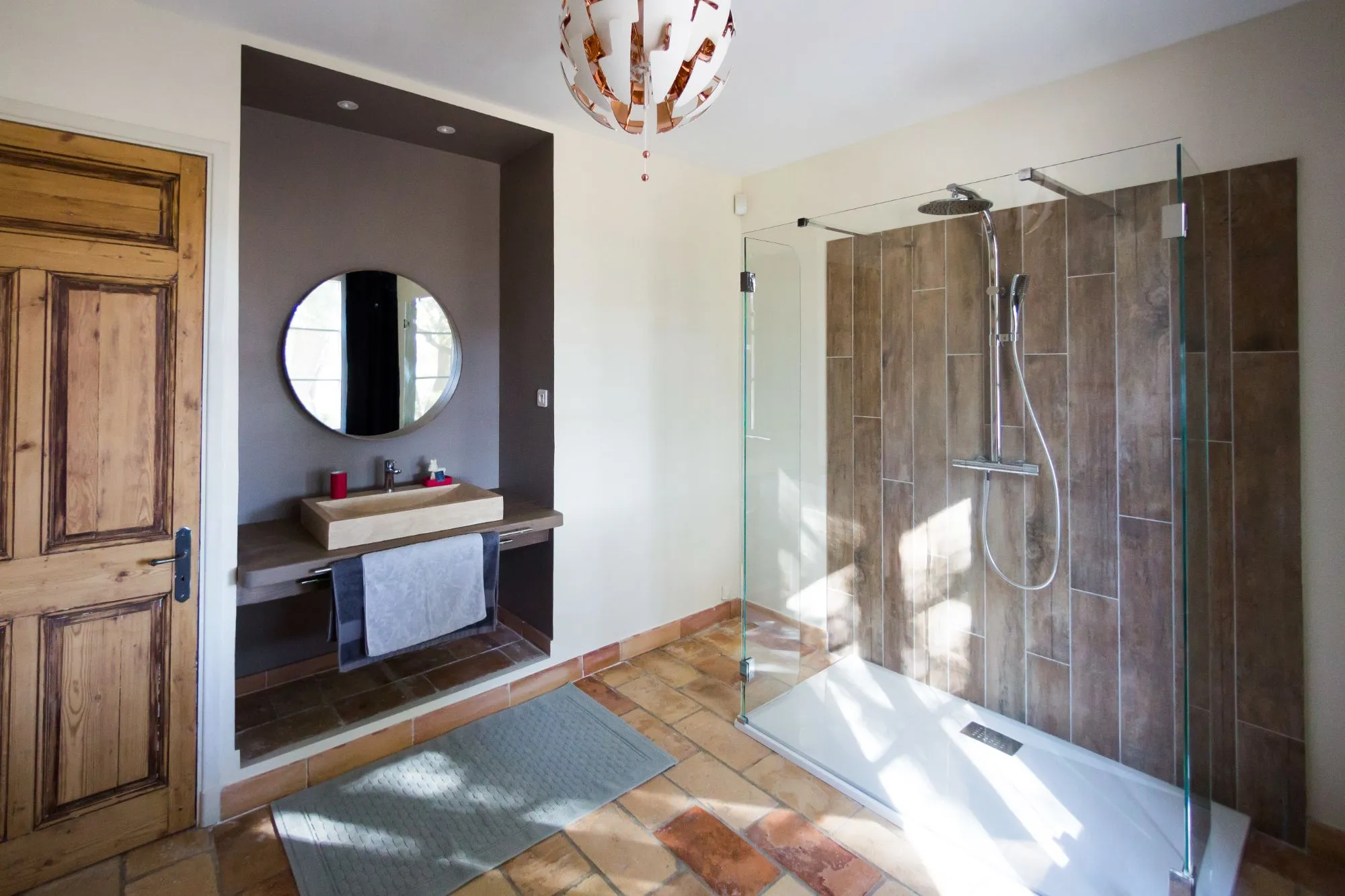 Salle d'eau avec douche vitrée et miroir rond