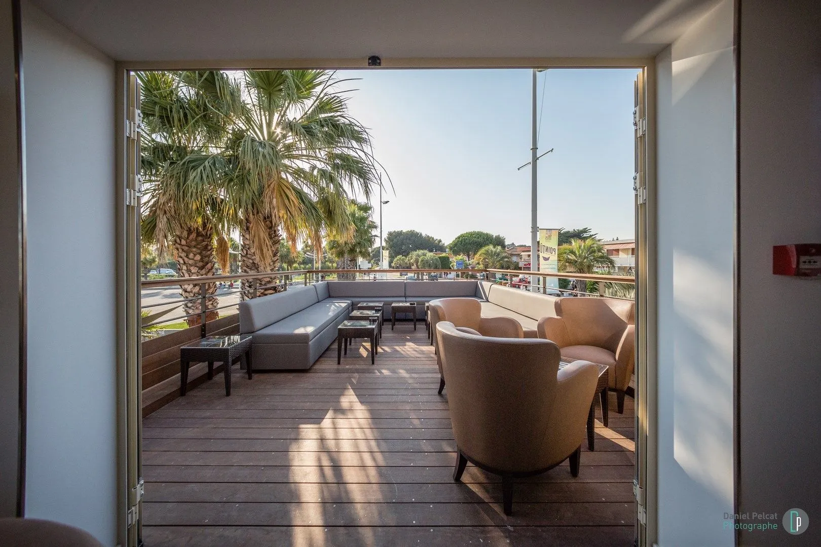 Terrasse lounge encadrée par une baie vitrée