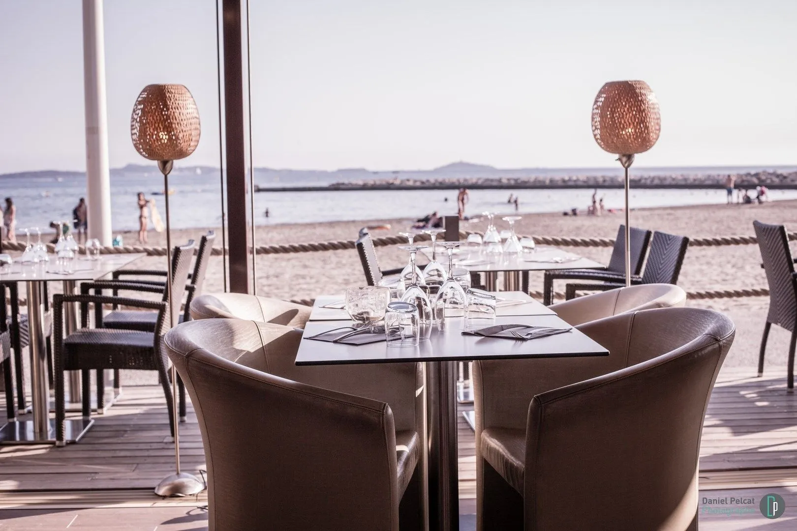 Table face à la mer, verres et fauteuils en cuir