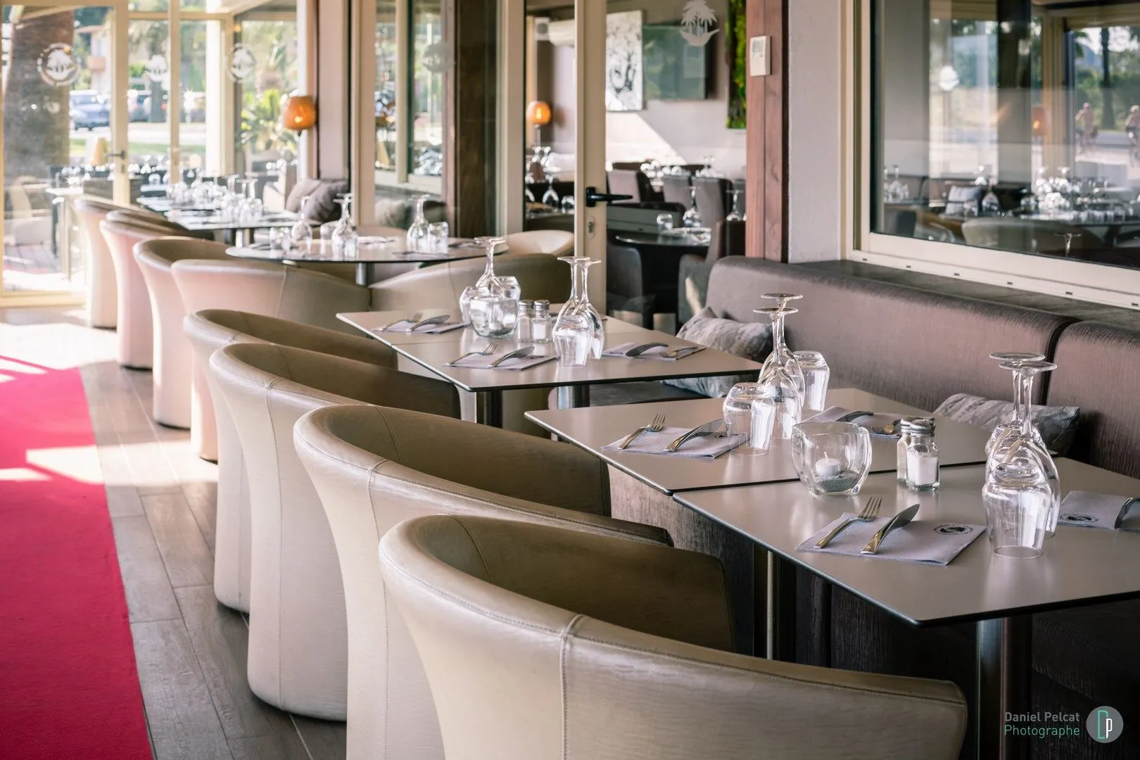 Rangée de tables dressées et fauteuils blancs