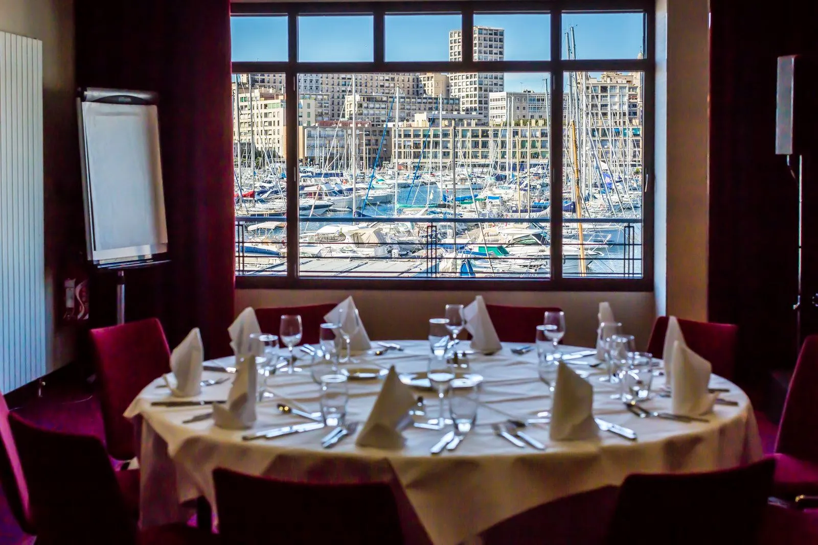 Table dressée devant une fenêtre donnant sur le port