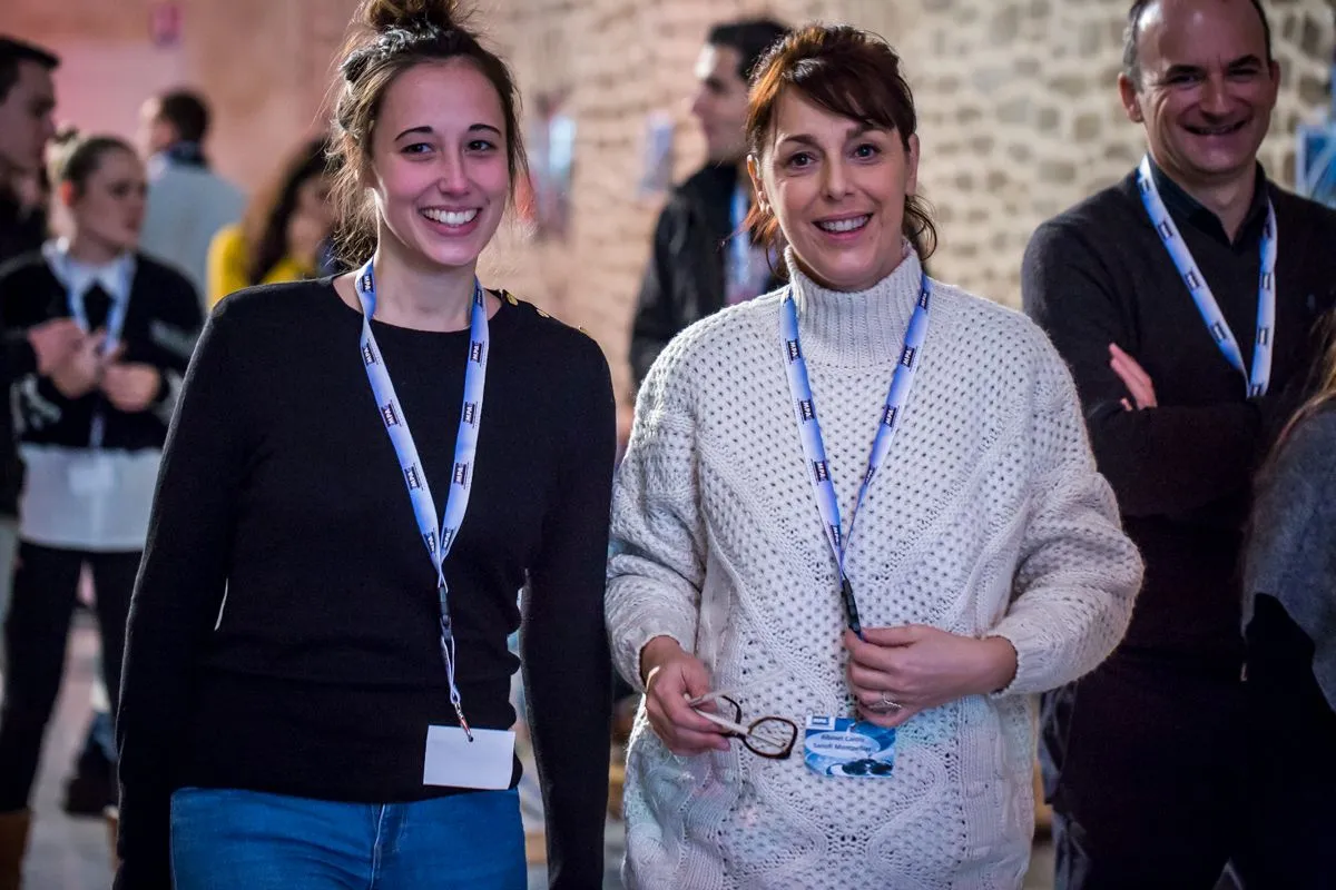 Trois participants souriants avec leur badge