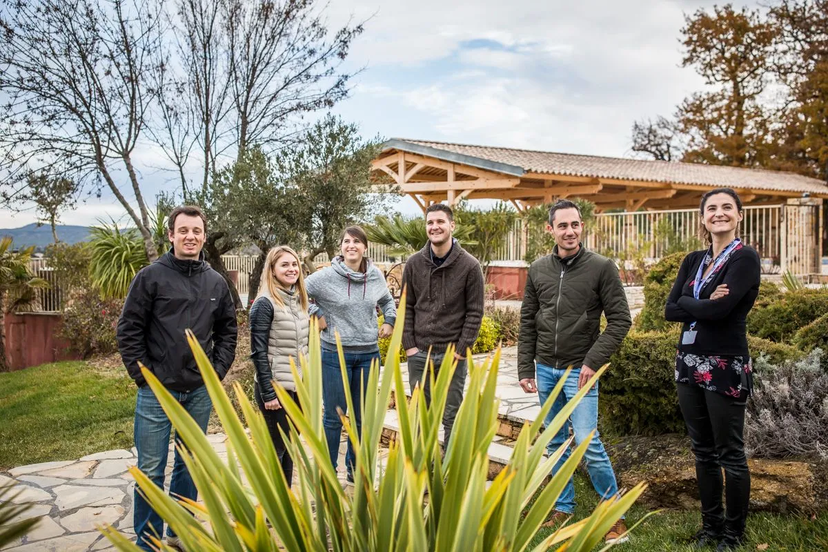 Équipe posant dans un jardin méditerranéen